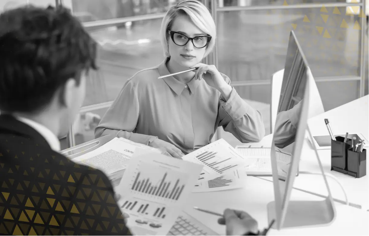 man and women discussing analytics in front of desktop