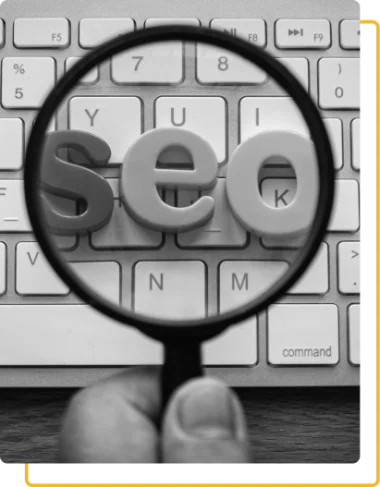 The letters SEO on a keyboard seen through a magnifying glass